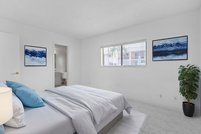 bedroom with connected bathroom and light tile patterned floors