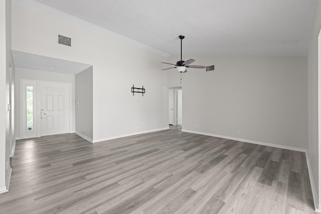 unfurnished living room with ceiling fan, high vaulted ceiling, a textured ceiling, and light hardwood / wood-style flooring