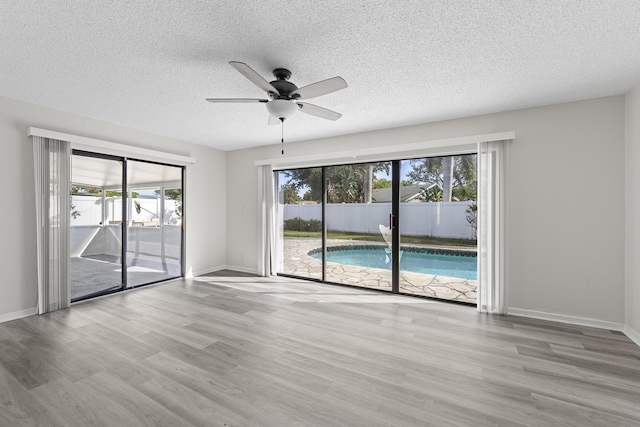 spare room featuring a textured ceiling, ceiling fan, and light wood-type flooring