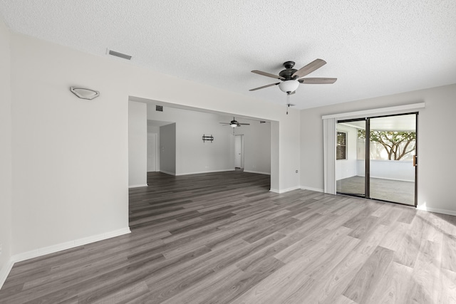 spare room with ceiling fan, a textured ceiling, and light wood-type flooring