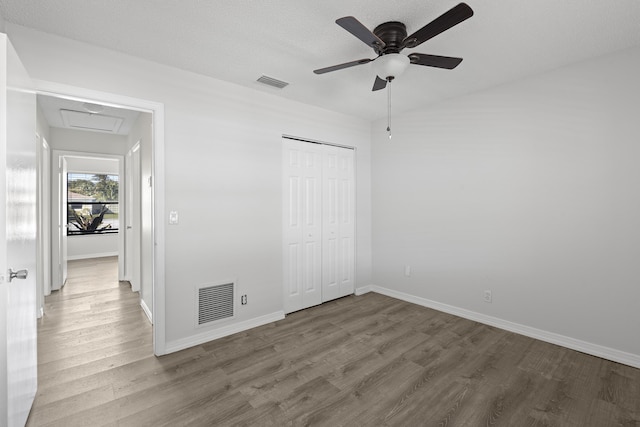 unfurnished bedroom with hardwood / wood-style floors, ceiling fan, and a closet