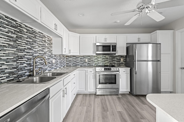 kitchen featuring white cabinetry, appliances with stainless steel finishes, sink, and light hardwood / wood-style flooring