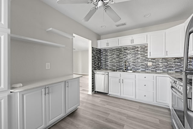 kitchen featuring tasteful backsplash, appliances with stainless steel finishes, sink, and white cabinets