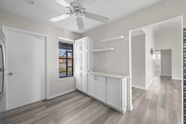 kitchen with ceiling fan, white cabinets, and light hardwood / wood-style floors