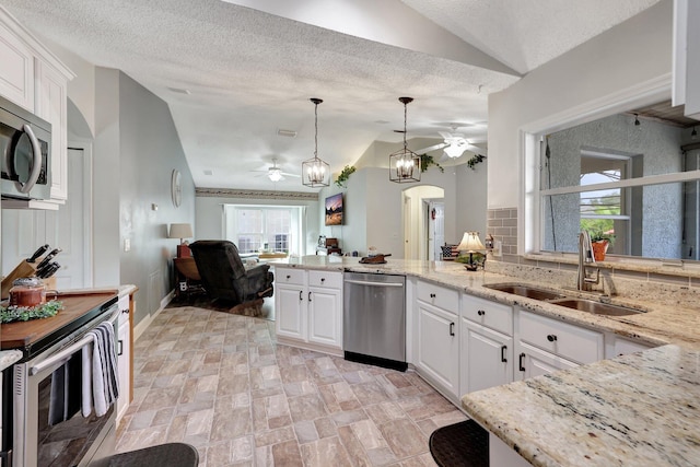 kitchen with white cabinetry, appliances with stainless steel finishes, decorative light fixtures, and sink