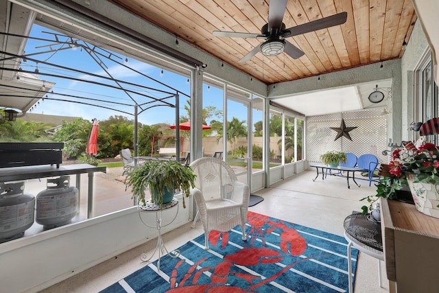 sunroom with wood ceiling and ceiling fan