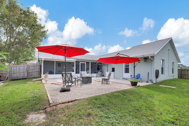 rear view of property with a yard, a patio, a fire pit, and a sunroom