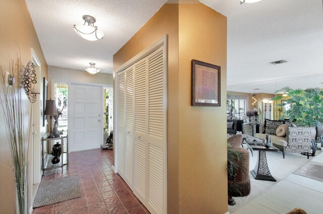 hallway featuring visible vents and a textured ceiling