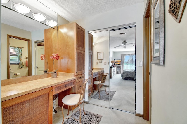 bathroom with ceiling fan, vanity, and a textured ceiling