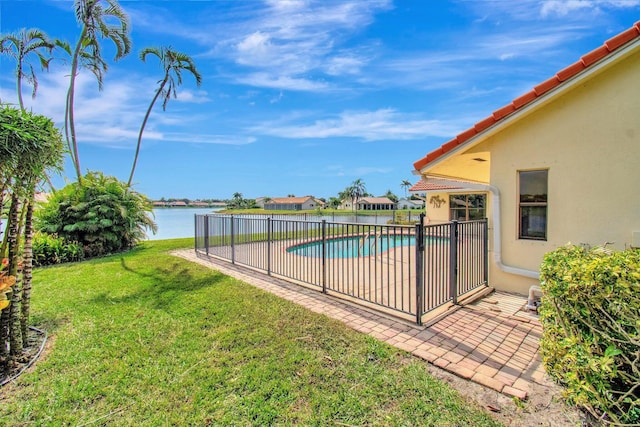 view of swimming pool with a water view and a lawn