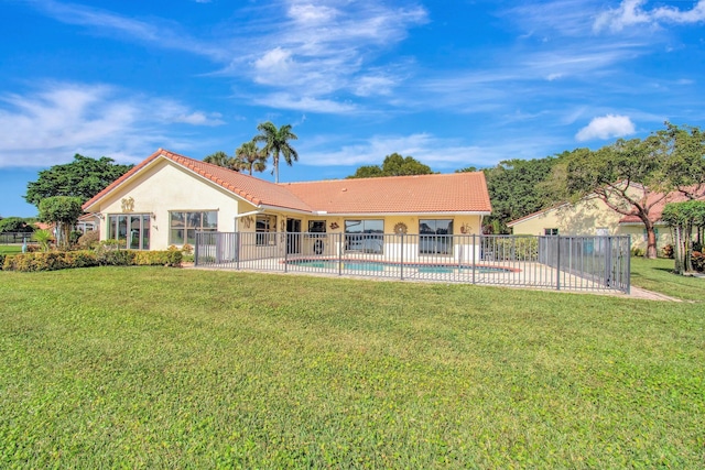 back of house featuring a fenced in pool, fence, a tiled roof, and stucco siding