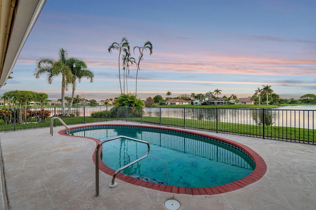 pool at dusk with a fenced in pool, a water view, a patio, and a fenced backyard