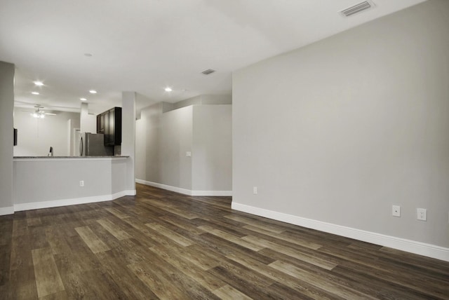 unfurnished living room with dark hardwood / wood-style flooring and ceiling fan