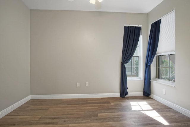 spare room with dark wood-type flooring and ceiling fan