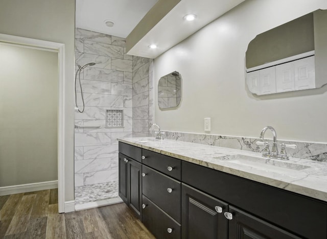 bathroom with vanity, tiled shower, and hardwood / wood-style floors