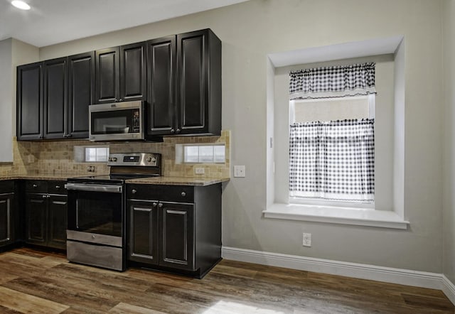 kitchen featuring tasteful backsplash, dark hardwood / wood-style flooring, stainless steel appliances, and stone counters