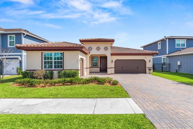 mediterranean / spanish-style house featuring a garage and a front lawn