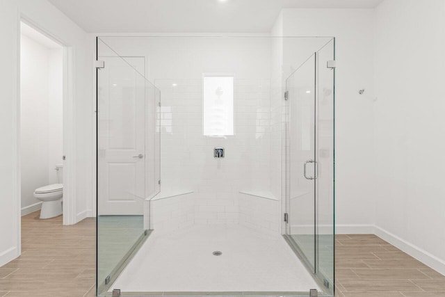 bathroom with a shower with shower door and toilet