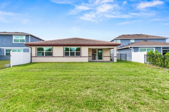 rear view of property with a yard and a patio area