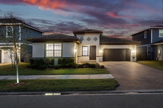 mediterranean / spanish-style house featuring a yard and a garage