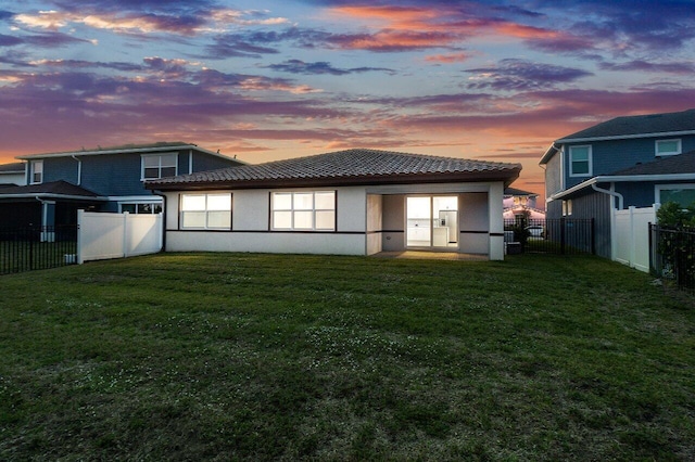 back house at dusk with a yard