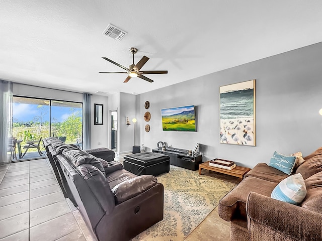 living room with ceiling fan, a textured ceiling, and light tile patterned floors