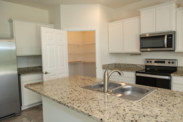 kitchen featuring stainless steel appliances, sink, white cabinets, and decorative light fixtures