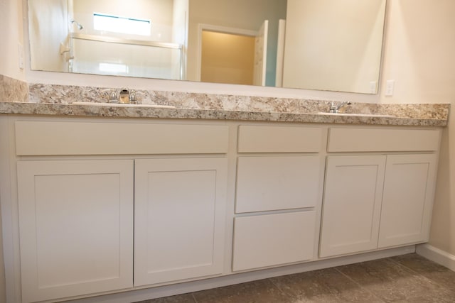 bathroom with vanity and a shower with door