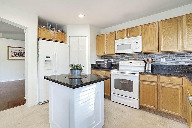 kitchen with white appliances, decorative backsplash, and a center island