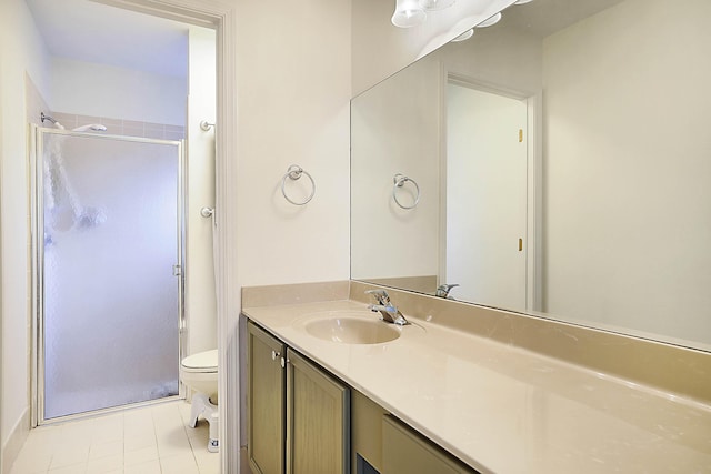 bathroom with tile patterned floors, vanity, toilet, and a shower with door