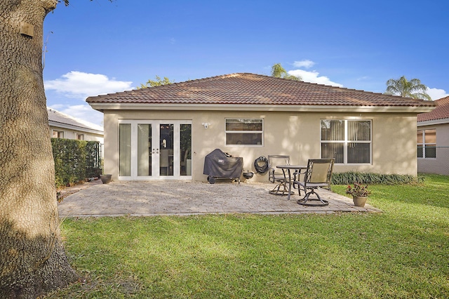 back of house featuring a patio area, french doors, and a lawn