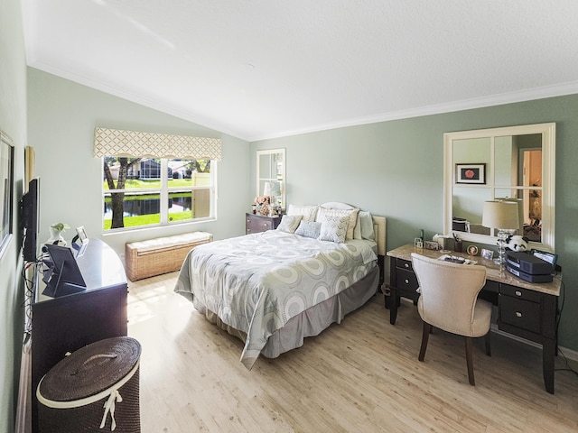 bedroom featuring crown molding, lofted ceiling, and light hardwood / wood-style floors