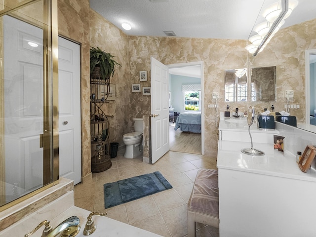 bathroom with vanity, a textured ceiling, tile patterned floors, and toilet