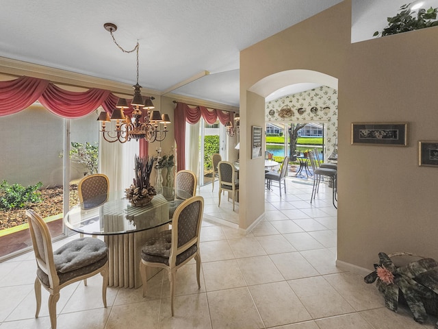 dining area with crown molding, light tile patterned floors, and a notable chandelier