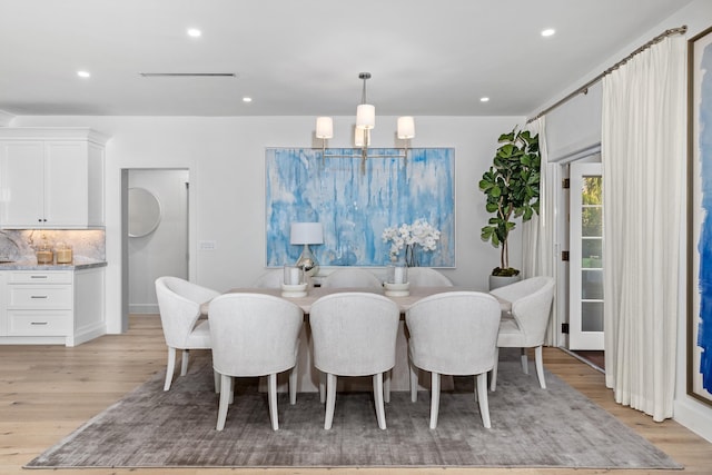 dining area featuring an inviting chandelier and light hardwood / wood-style floors