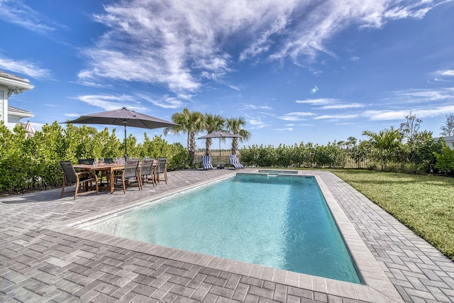 view of swimming pool with a patio, an in ground hot tub, and a lawn