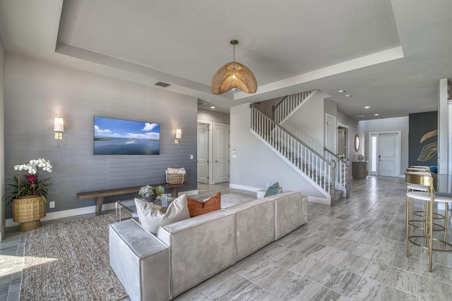 living room with a textured ceiling and a raised ceiling