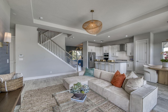 living room featuring light wood-type flooring and a tray ceiling