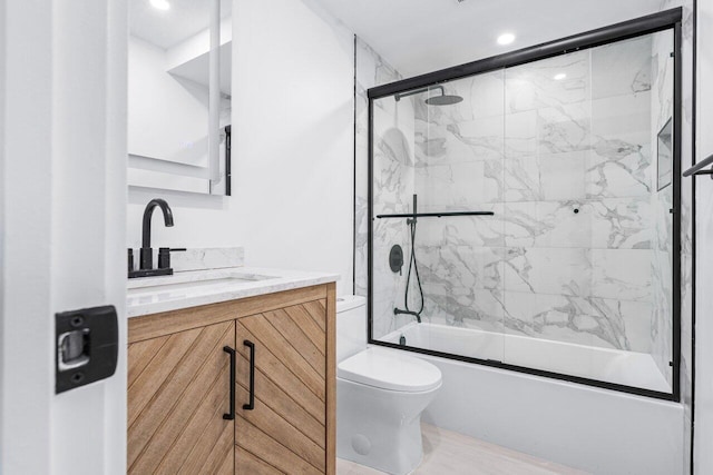 full bathroom with toilet, vanity, and bath / shower combo with glass door