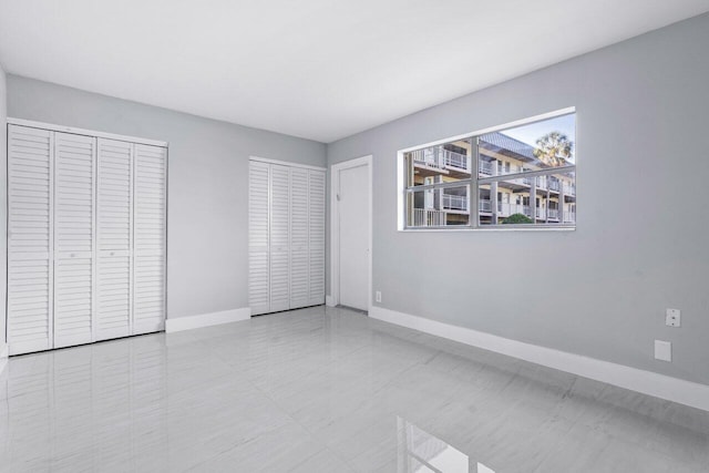 unfurnished bedroom featuring multiple closets