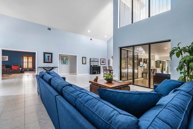 tiled living room featuring a high ceiling and a wealth of natural light