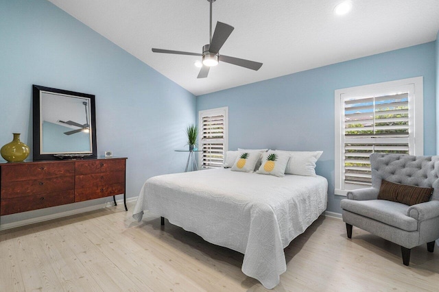 bedroom with light hardwood / wood-style flooring, vaulted ceiling, and ceiling fan