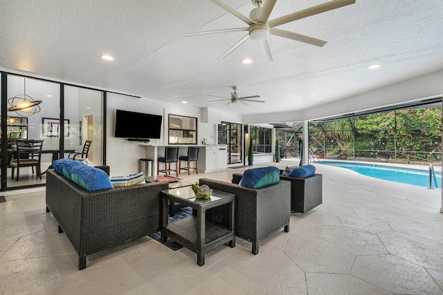 living area with recessed lighting, a textured ceiling, and ceiling fan