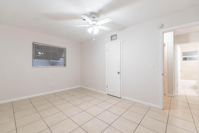 tiled spare room with ceiling fan