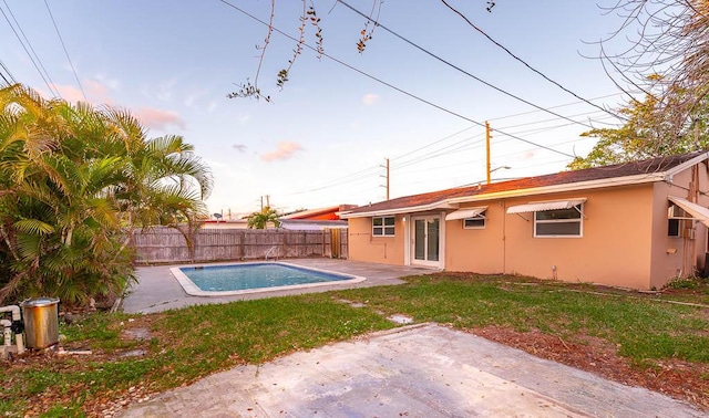 view of swimming pool featuring a lawn and a patio