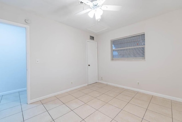 empty room with ceiling fan and light tile patterned floors