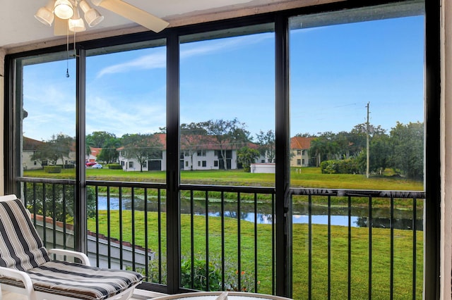 sunroom / solarium with ceiling fan and a residential view