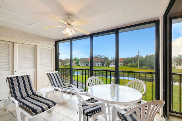 sunroom / solarium with a water view and ceiling fan