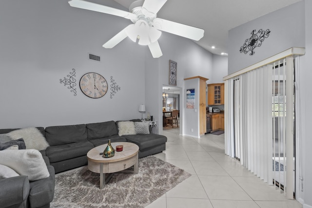 living room featuring a towering ceiling, ceiling fan, and light tile patterned flooring