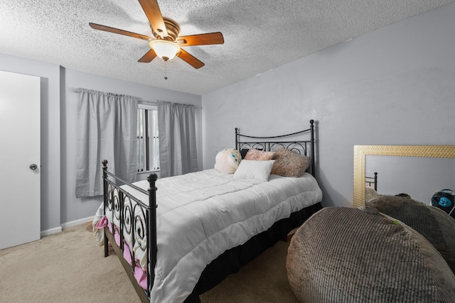 carpeted bedroom featuring ceiling fan and a textured ceiling